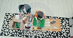 Teamwork, shipping and fashion designer people wrapping a product in office for courier delivery from above. Box