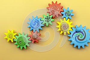 Teamwork and solidarity concept related colorful plastic toy gears, each gear is a different color on a blue background with copy