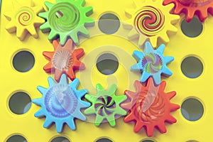 Teamwork and solidarity concept related colorful plastic toy gears, each gear is a different color on a blue background with copy