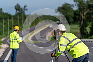 Teamwork of surveyor engineers worker making measuring with theodolite instrument equipment during construction road works, Civil
