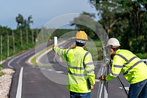 Teamwork of surveyor engineers worker making measuring with theodolite on road works. survey engineer at road construction site,