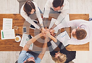 Teamwork and teambuilding concept in office, people connect hands photo