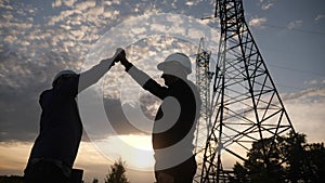 Teamwork. two electricians engineer shake hands. business partnership energy technology industry a concept. silhouette