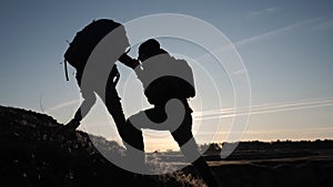 Teamwork two men help helping hand business travel silhouette concept lifestyle . two tourists lends a helping hand