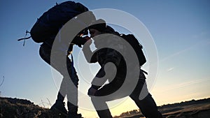 Teamwork two men help helping hand business travel silhouette concept. two tourists lends a helping hand climb the