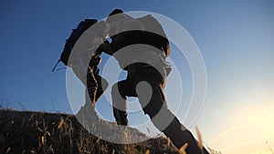 Teamwork two men help helping hand business travel silhouette concept. two tourists lends a helping hand climb lifestyle