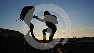 Teamwork two men help helping hand business travel silhouette concept. two tourists lends a lifestyle helping hand climb