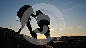 Teamwork two men help helping hand business travel silhouette lifestyle concept. two tourists lends a helping hand climb