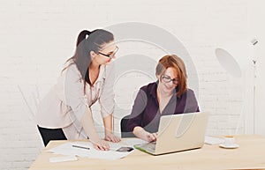 Teamwork. Women discuss project in office