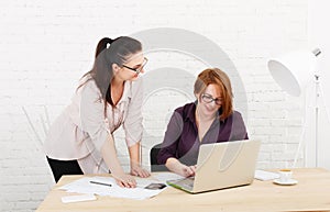 Teamwork. Women discuss project in office