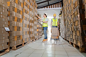 Teamwork of Workers In Warehouse preparing goods cardboard boxes on a pallet in warehouse for dispatch