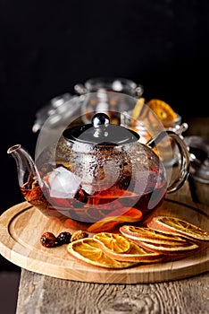 Teapot of Black Tea with Dried Oranges and Berries on the Wooden Tray Dried Citrus Wooden Background Hot Winter or Autumn Beverage