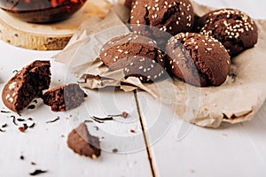 Teapot with black tea and homemade chocolate cookies on a white natural wooden background