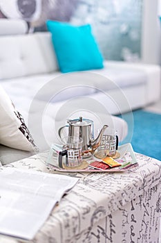 Teapot and cups set up on a tray in the living room, bright light mood - still life