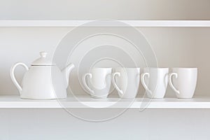 Teapot and cups on the shelf