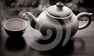 Teapot and empty cup on wooden table