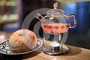 Teapot with ginger tea and bread