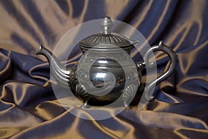 Teapot on a grey drapery background