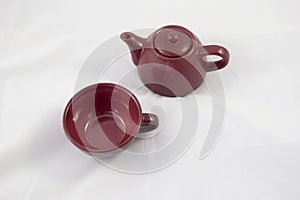 Maroon ceramic teapot on white background photo