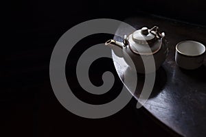 Teapot on table with cup