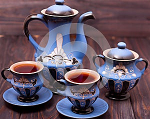 Teapot and two cups of tea on a wooden background