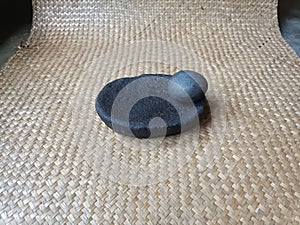 Tear off river stone lado on a woven pandan leaf mat photo