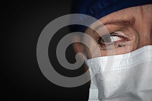 Tearful Stressed Female Doctor or Nurse Crying Wearing Medical Face Mask on Dark Background