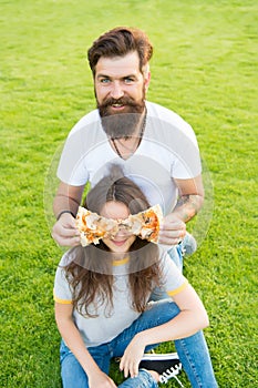 Teasing her with food. Fast food. Bearded man feeding woman cheesy pizza. Couple in love dating outdoors eat pizza