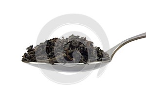 Teaspoon with dark black tea leaf isolated photo