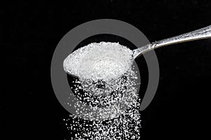 Teaspoon with sugar dunes and granulated sugar