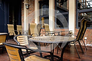 Teatable and chairs on planked floor outside red brick building