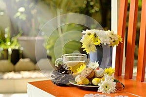 Teatime with Chinese pastry and tea and flower on a orange chair