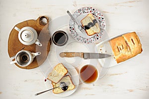 Teaware with homemade cake on white table topview