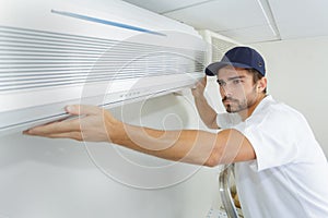 Tech guy carefully installing new ac photo