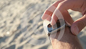 Tech man using smart watch to track beach training,hi tech healthy fit device