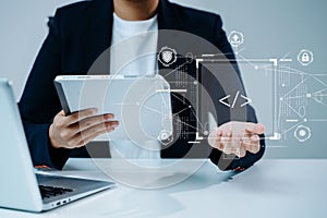 Tech professional using tablet and digital interface with code. Concept of cybersecurity, innovation, software development