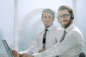 Tech support manager in headset consulting a client