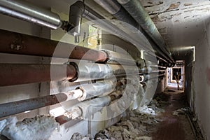 technical corridor with pipes that have torn thermal insulation