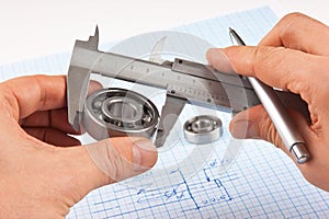 Technical drawing and callipers with bearing in hand