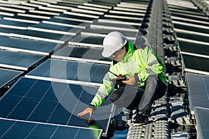 Technical expert in solar energy photovoltaic panels, remote control performs routine actions for system monitoring using clean,