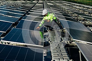 Technical expert in solar energy photovoltaic panels, remote control performs routine actions for system monitoring using clean,