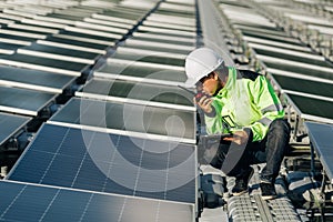Technical expert in solar energy photovoltaic panels, remote control performs routine actions for system monitoring using clean,