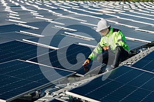 Technical expert in solar energy photovoltaic panels, remote control performs routine actions for system monitoring using clean,