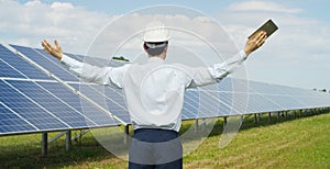 Technical expert in solar energy photovoltaic panels, remote control performs routine actions for system monitoring using clean, r