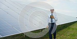 Technical expert in solar energy photovoltaic panels, remote control performs routine actions for system monitoring using clean, r