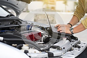 Technical man is using laptop to tuning racing car with engine bay