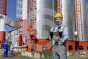 Technical Manager, Engineer and Power Plant Worker Working in front of Industrial Chimneys