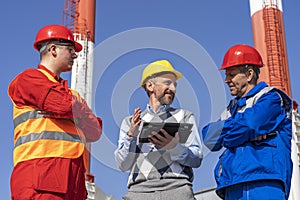 Technical Manager Using Digital Tablet and Discussing About Production Process with Two Workers