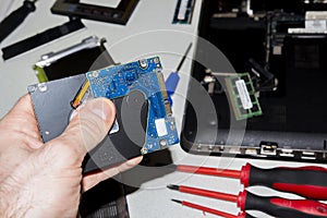Technical service of laptops. Parts of computer. Hard drive from laptop in the hand