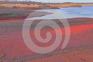 Technical settler of industrial water of mining industry with red soil polluted with iron ore waste in Kryvyi Rih, Ukraine photo